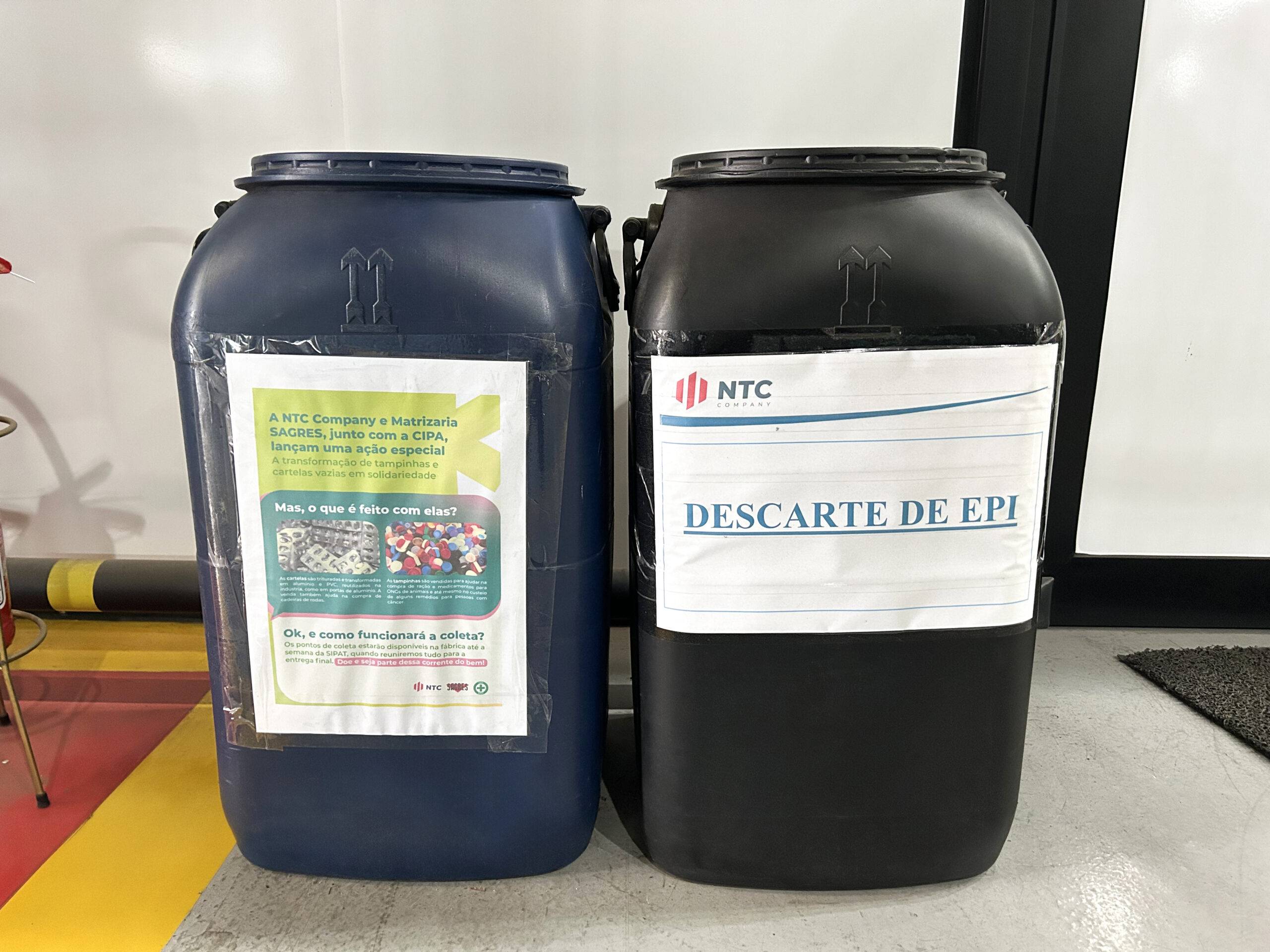 Ponto de coleta interna da NTC Company com tambores para descarte de EPI e campanha solidária de arrecadação de tampinhas plásticas e cartelas de medicamentos, promovendo responsabilidade ambiental e ações sociais.
