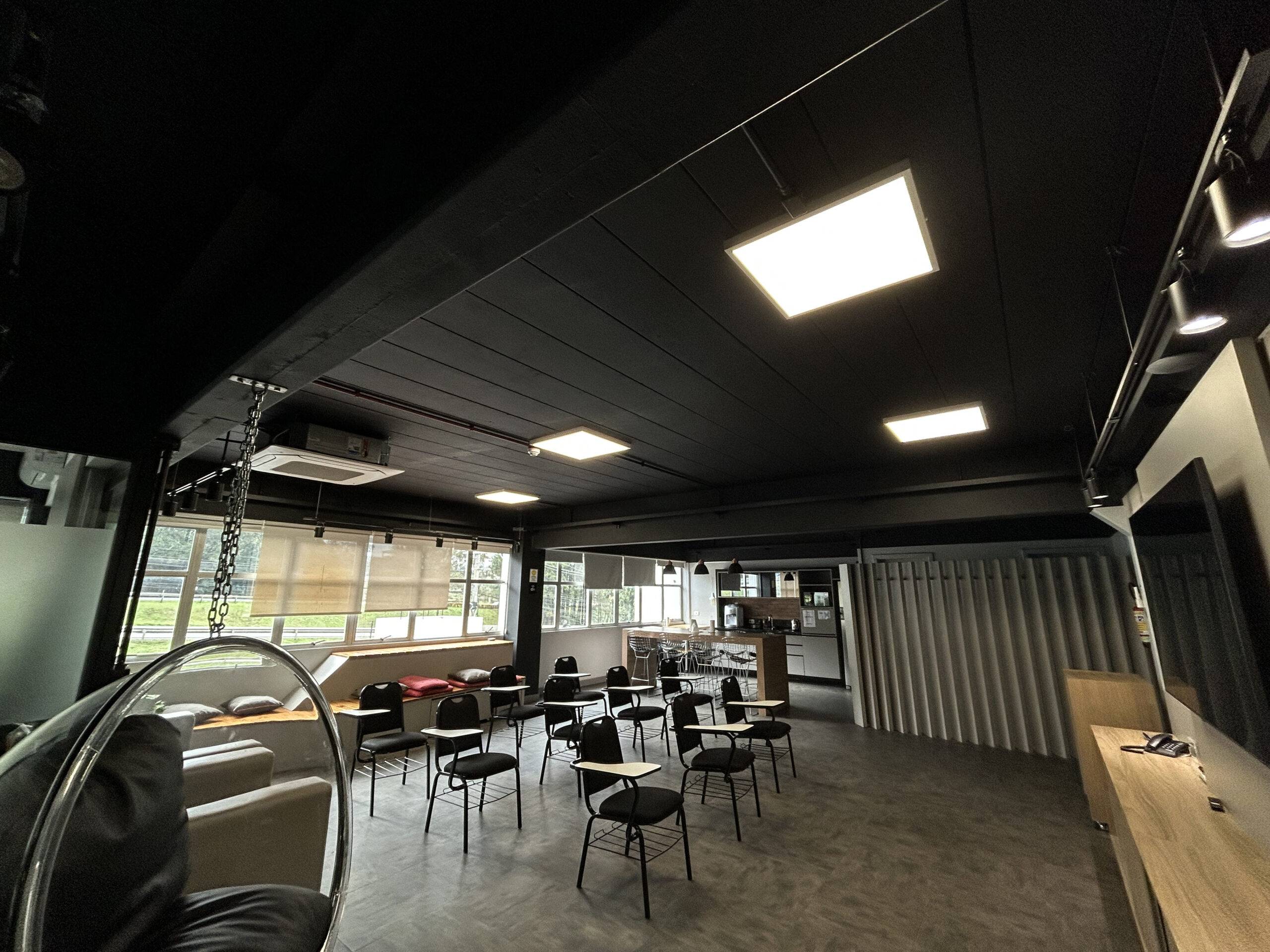 Ambiente interno da NTC Company com iluminação em painéis de LED embutidos, proporcionando eficiência energética, conforto visual e sustentabilidade no espaço de convivência e treinamentos.
