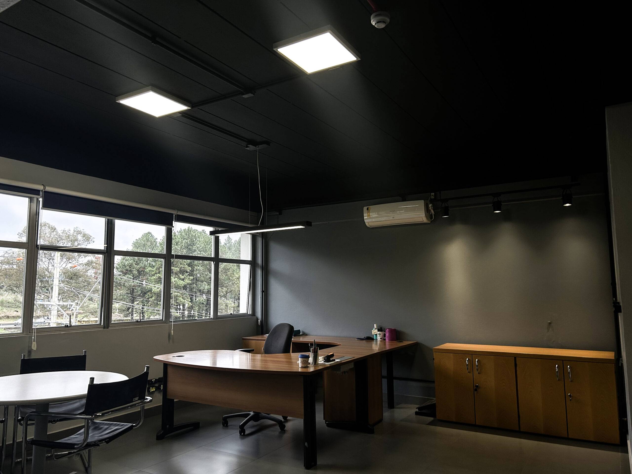 Escritório corporativo da NTC Company com iluminação LED integrada ao teto e ampla entrada de luz natural, promovendo eficiência energética, conforto visual e bem-estar no ambiente de trabalho.