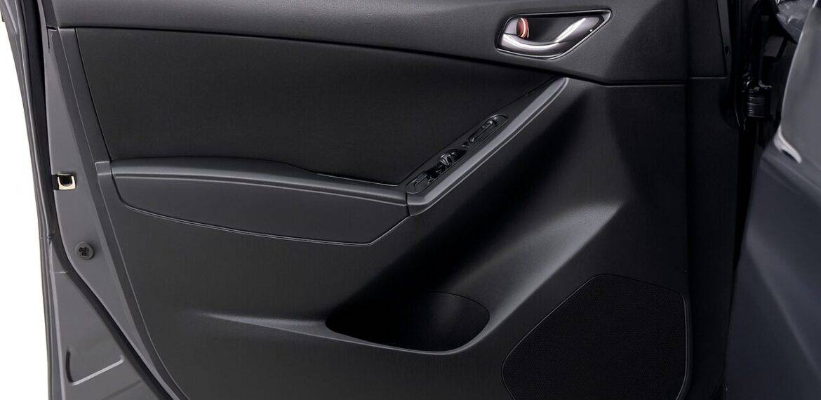 Painel interno de porta automotiva em plástico de engenharia, mostrando acabamento resistente e design funcional.