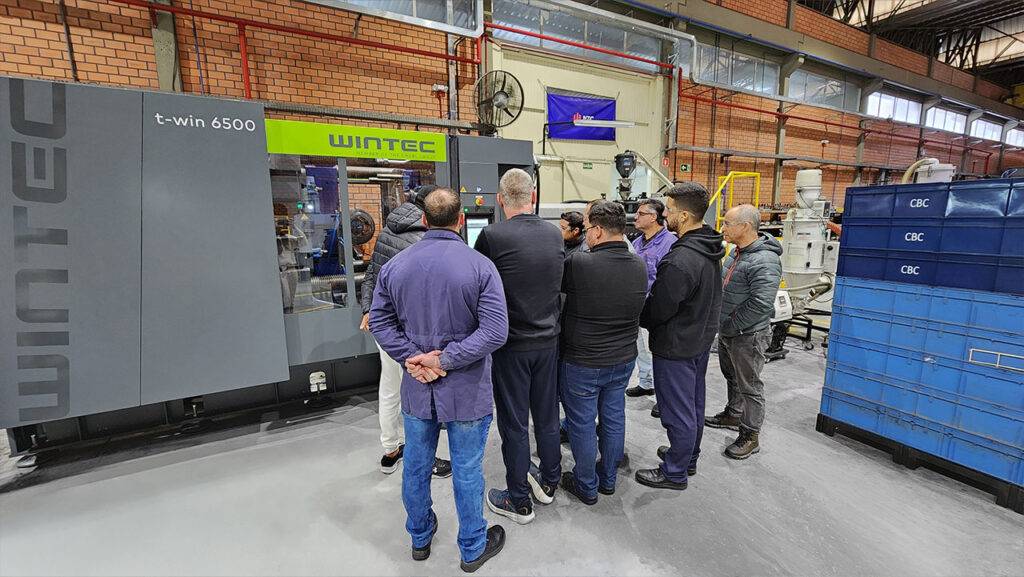 Equipe da NTC durante treinamento operacional da injetora ENGEL t-win 6500.