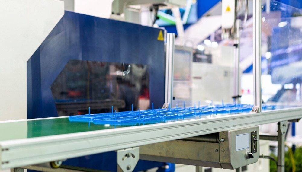 Equipamento industrial fabricando componentes plásticos, representando injeção plástica ou impressão 3d em processos produtivos.