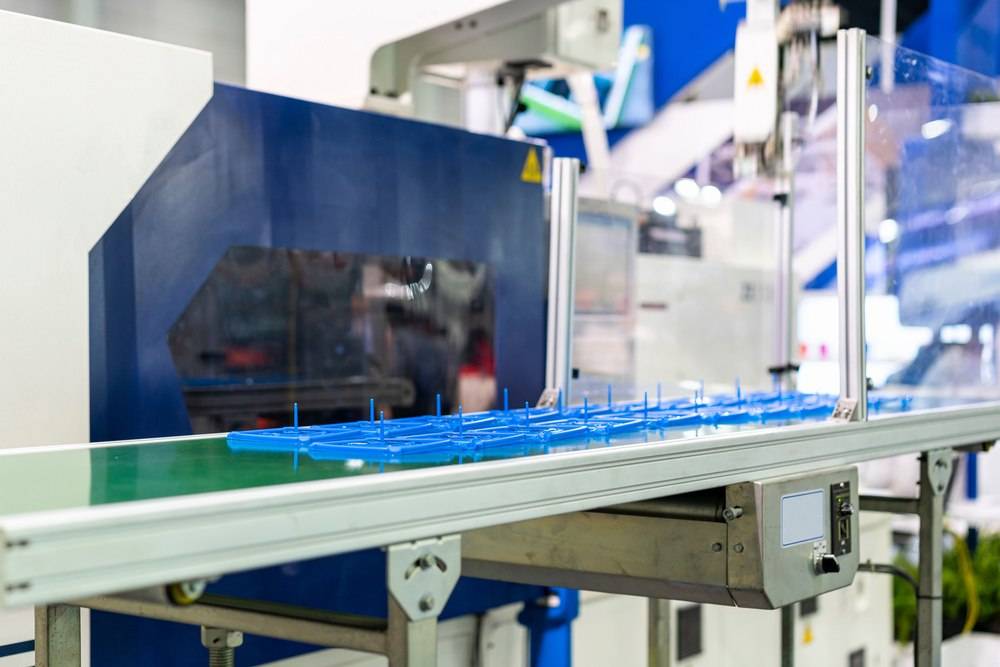 Equipamento industrial fabricando componentes plásticos, representando injeção plástica ou impressão 3d em processos produtivos.